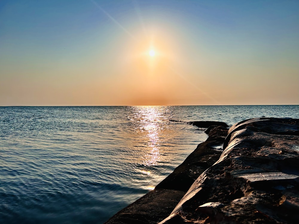 the sun is setting over the ocean and the water