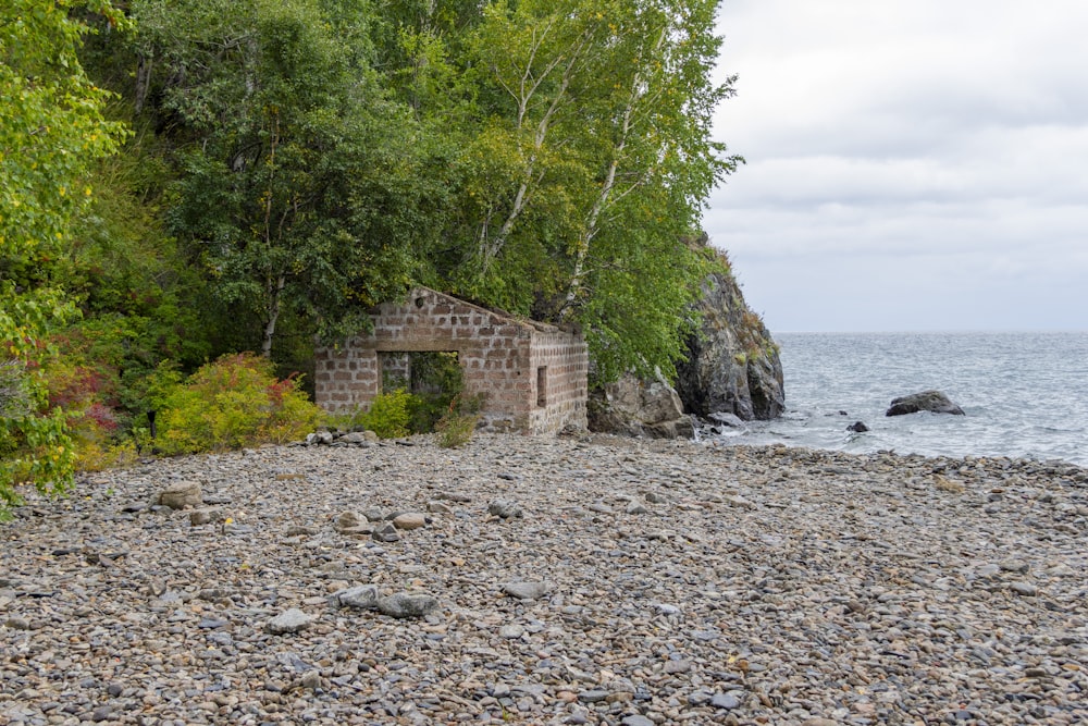 an old brick building sitting on top of a rocky beach