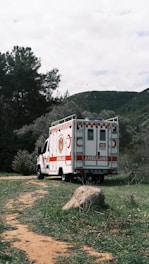 an ambulance parked on the side of a dirt road