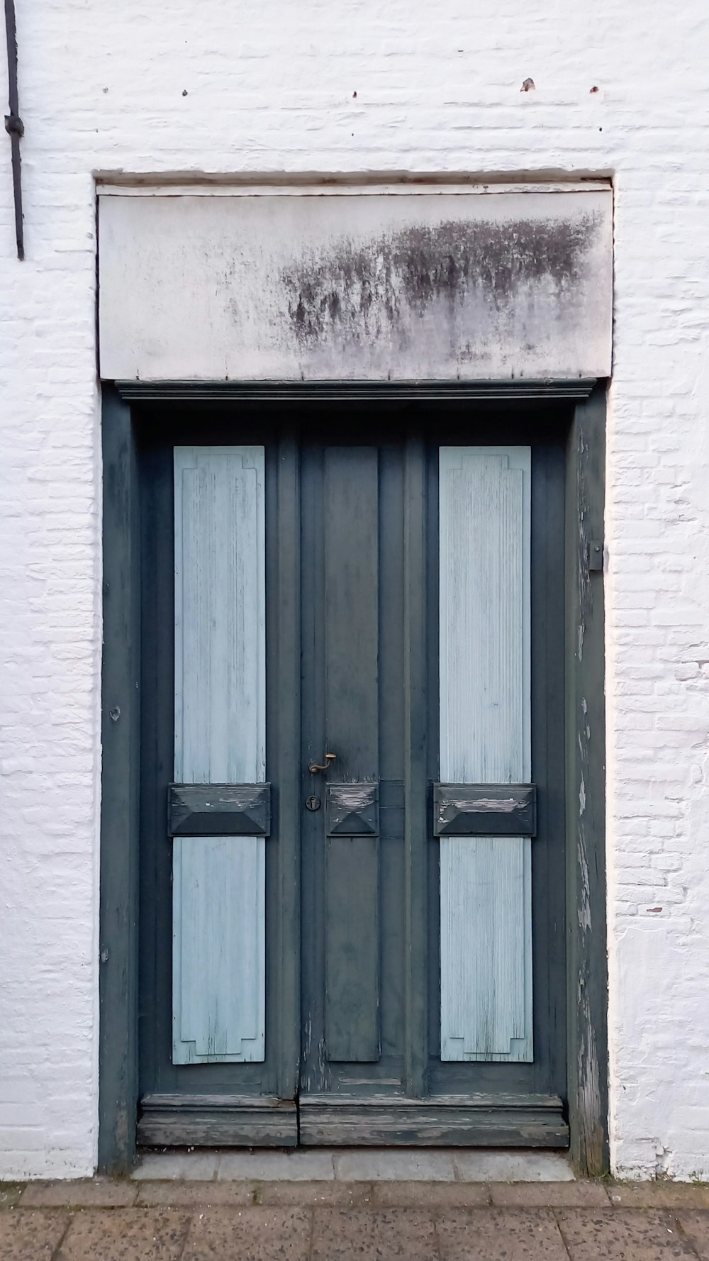 a black and white door and window on a white brick building