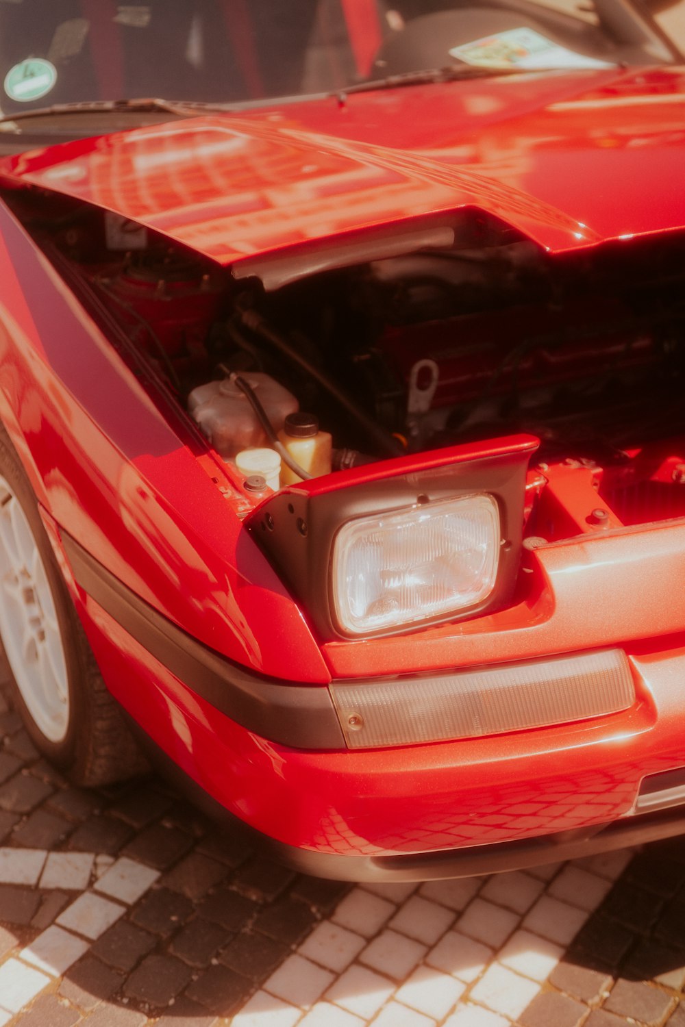 a red sports car with its hood open