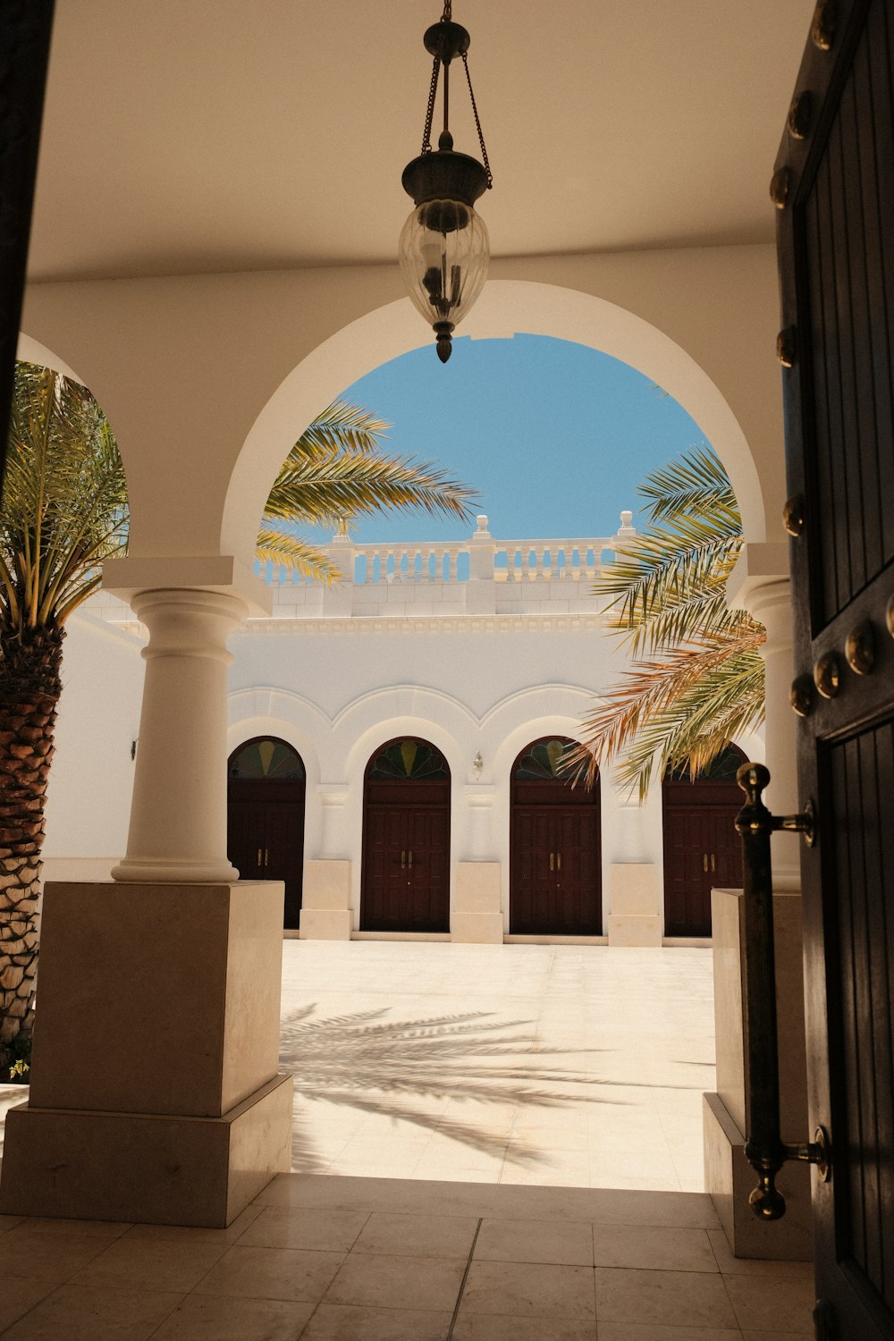 an archway leading to a building with palm trees