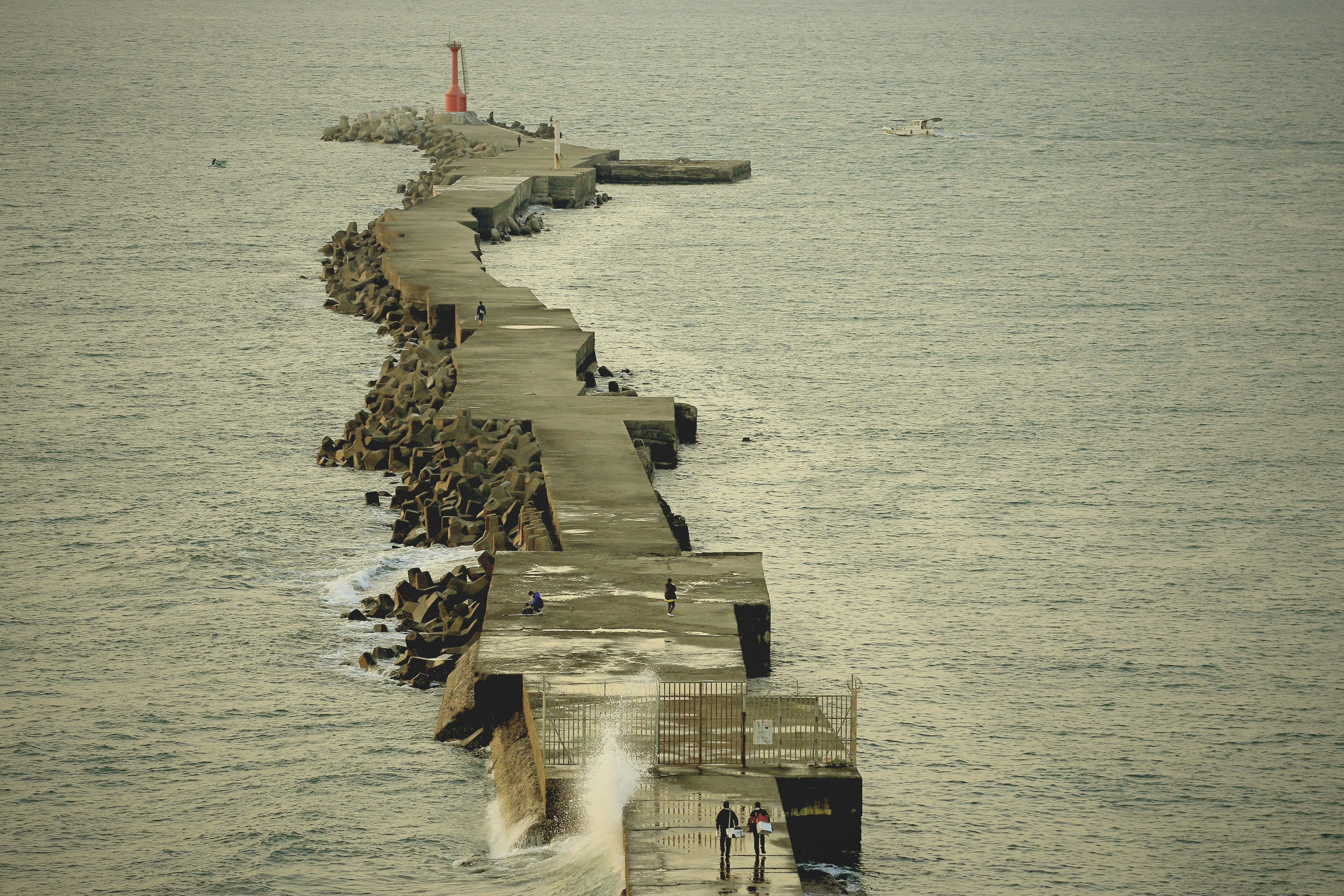 a long pier with a couple of people standing on it
