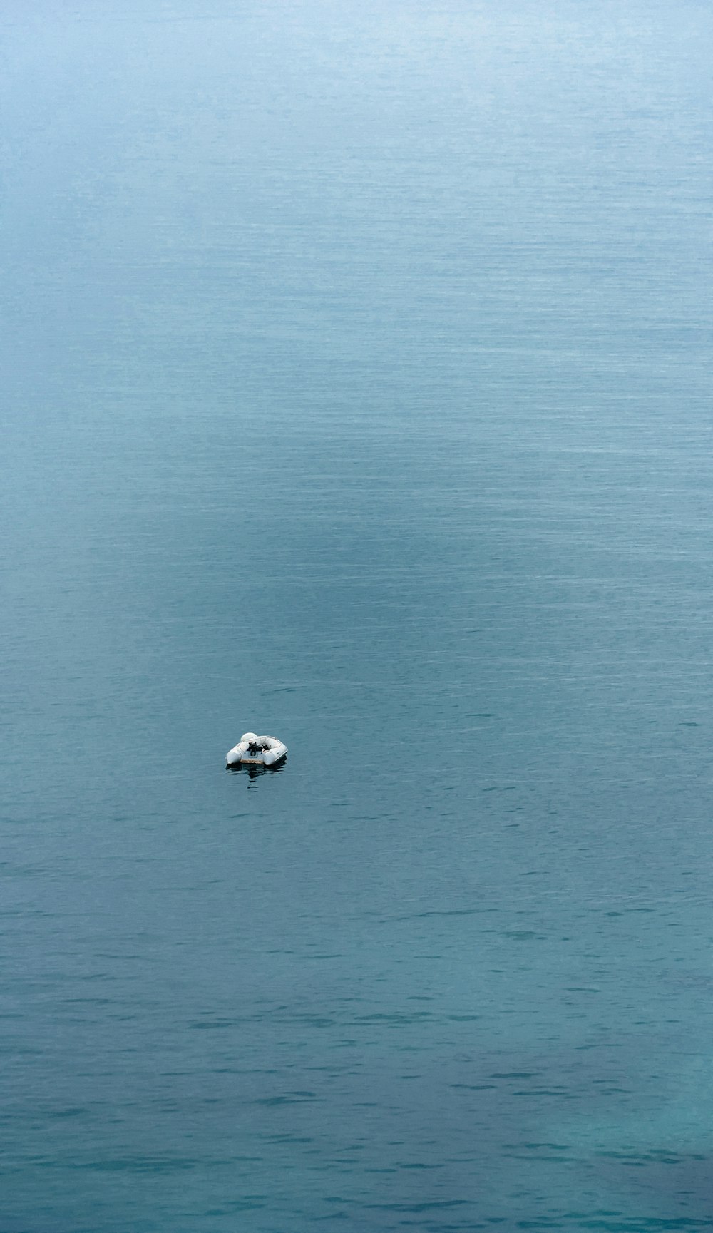 a small boat floating on top of a large body of water