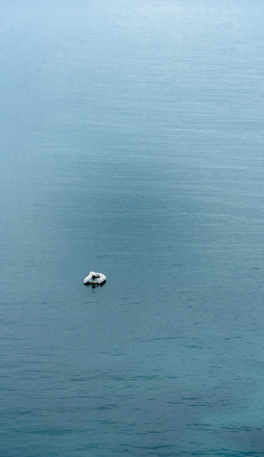 ein kleines Boot, das auf einem großen Gewässer schwimmt