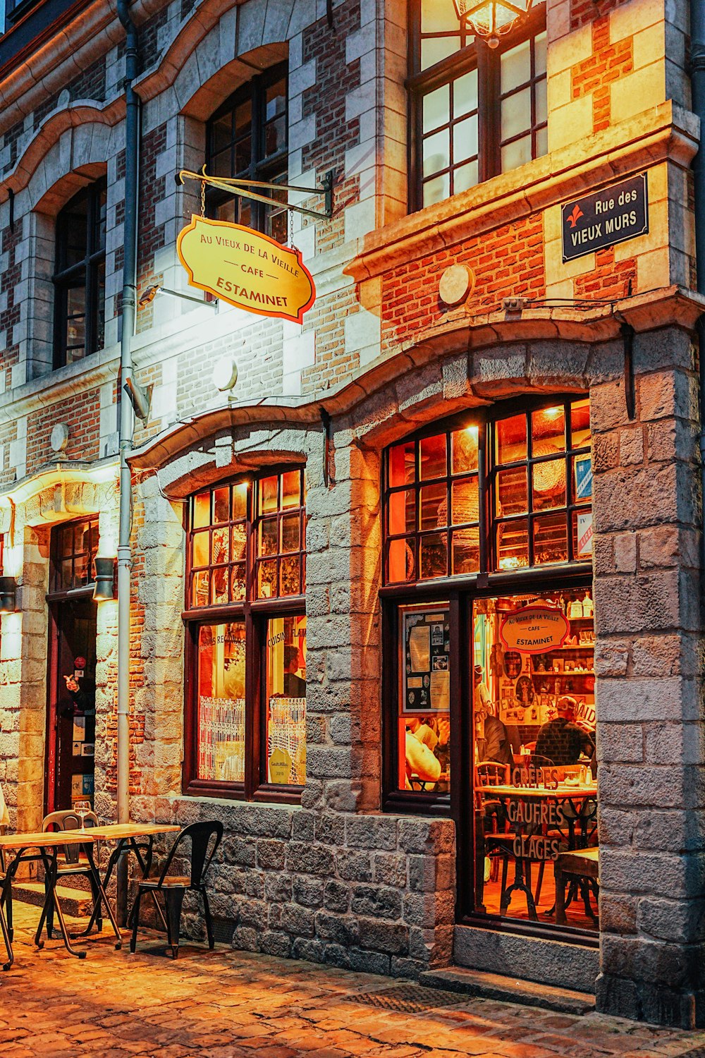 a brick building with tables and chairs in front of it