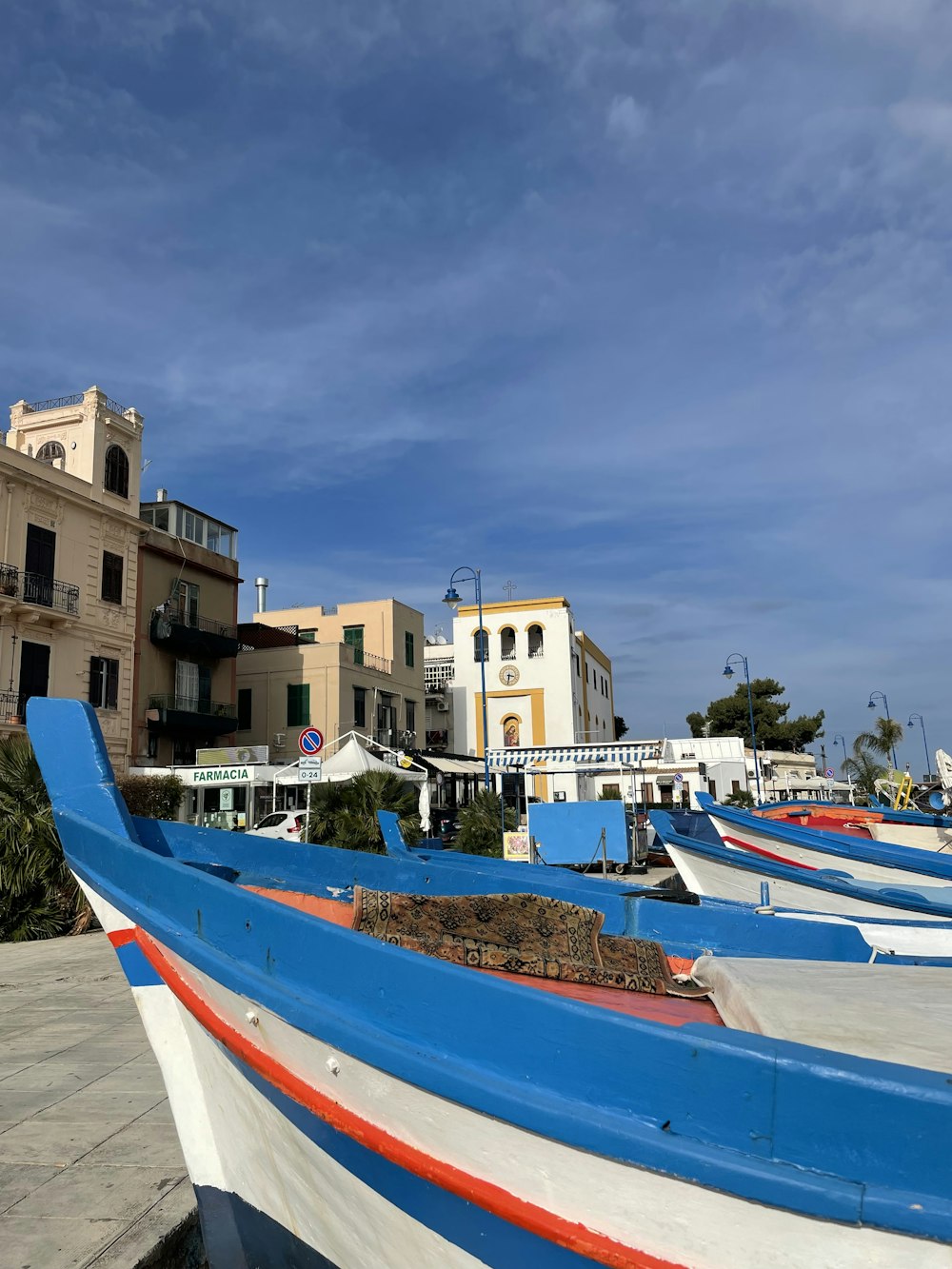 a row of boats sitting on top of a cement ground