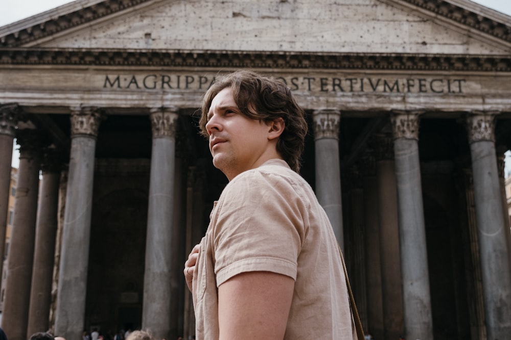 a man standing in front of a building with columns