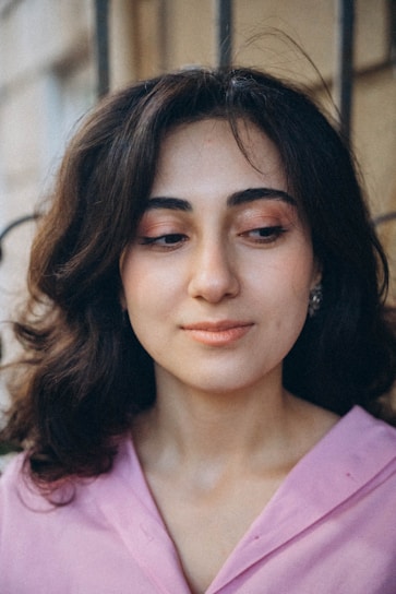 a close up of a person wearing a pink shirt