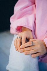 a woman in a pink shirt is holding a ring