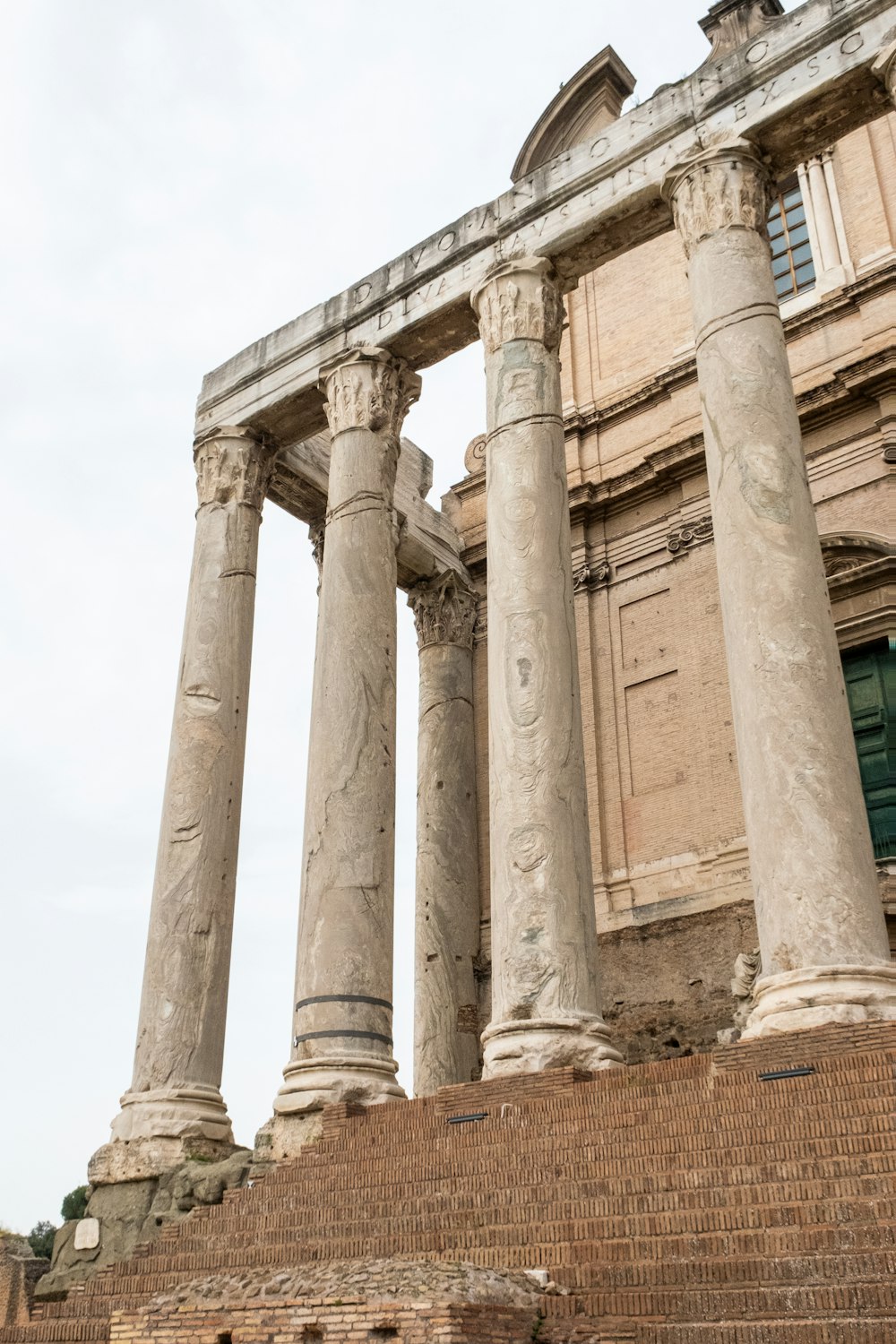 an old building with four pillars and a clock