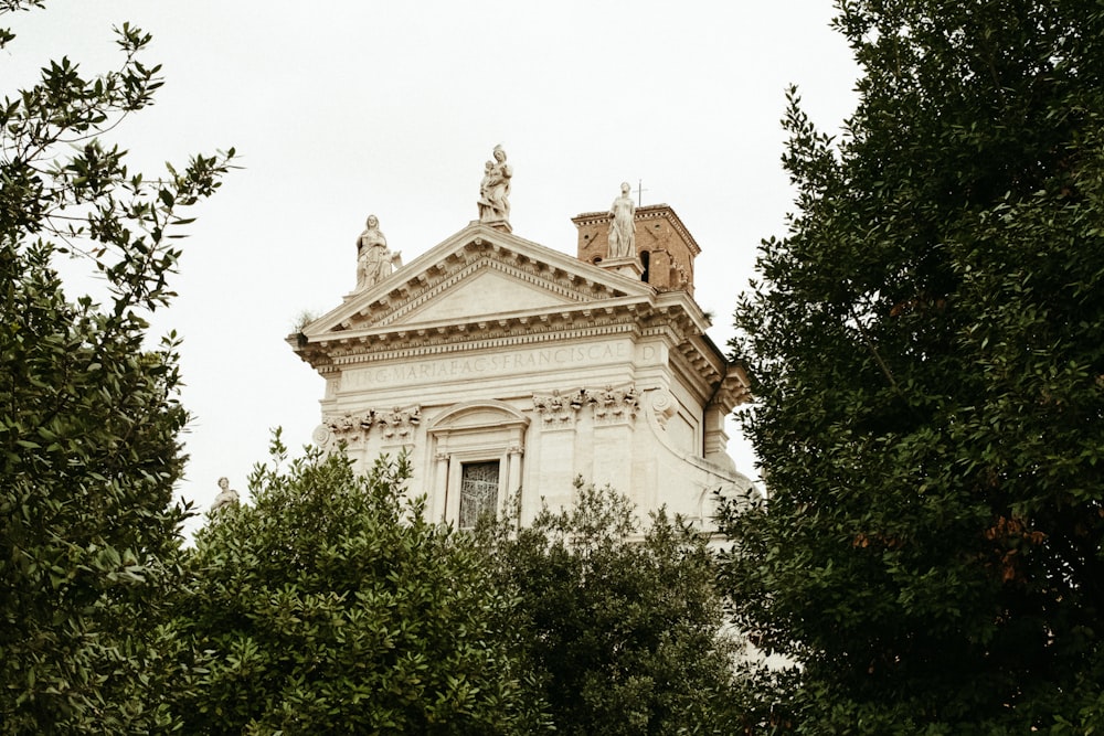 a tall white building surrounded by trees