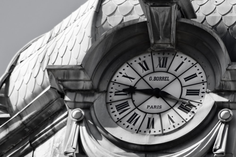 a black and white photo of a clock on a building