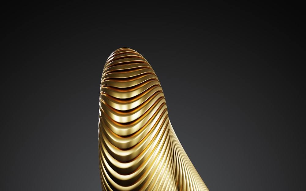 a gold sculpture is shown against a black background
