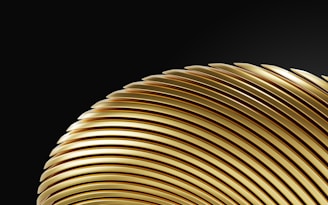 a close up of a gold object on a black background