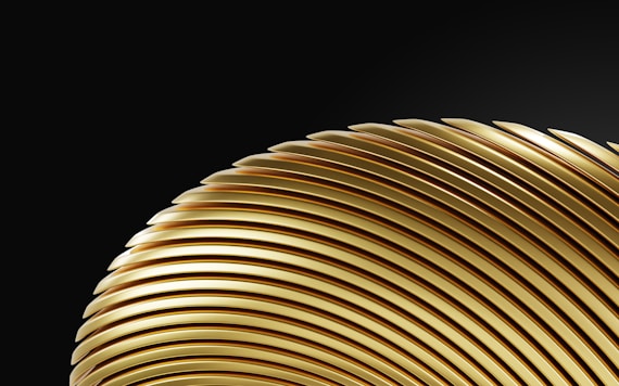 a close up of a gold object on a black background
