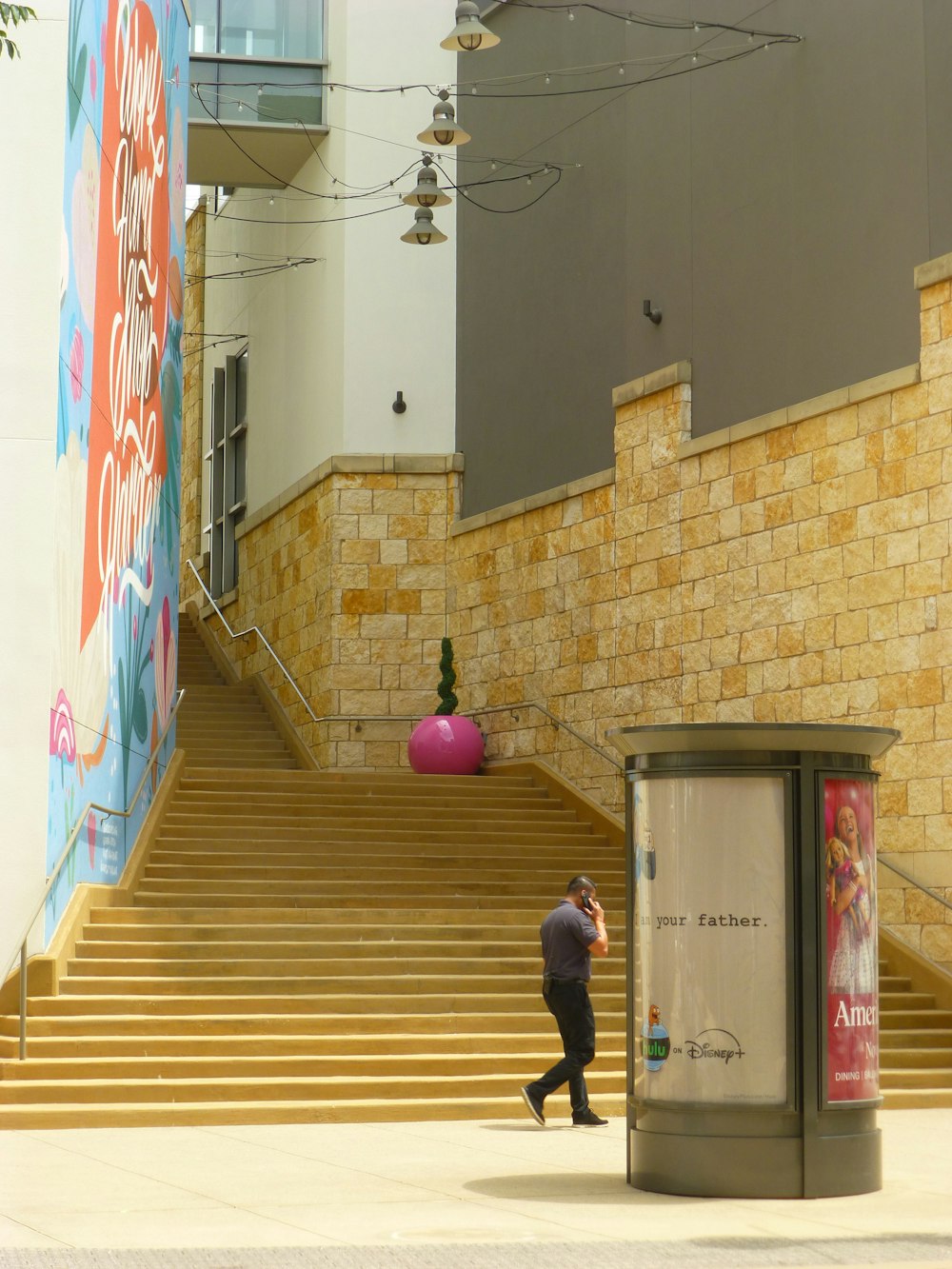 a man walking down a flight of stairs next to a trash can
