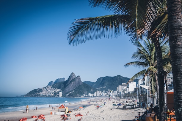 a crowded beach with a mountain in the background