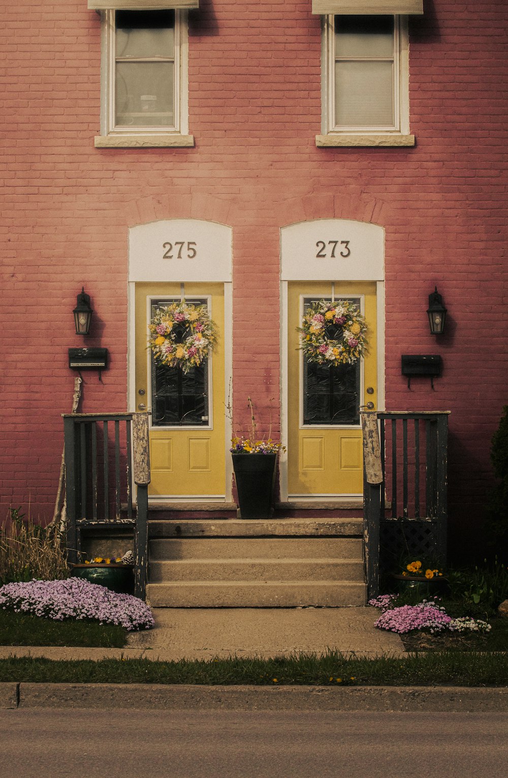 a couple of yellow doors sitting on the side of a building