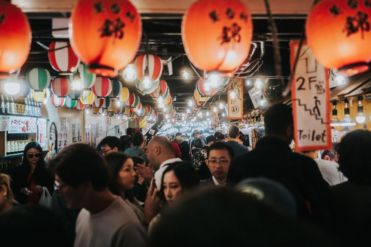 Crowd of visitors walking through a bustling covered market arcade in Kyoto
