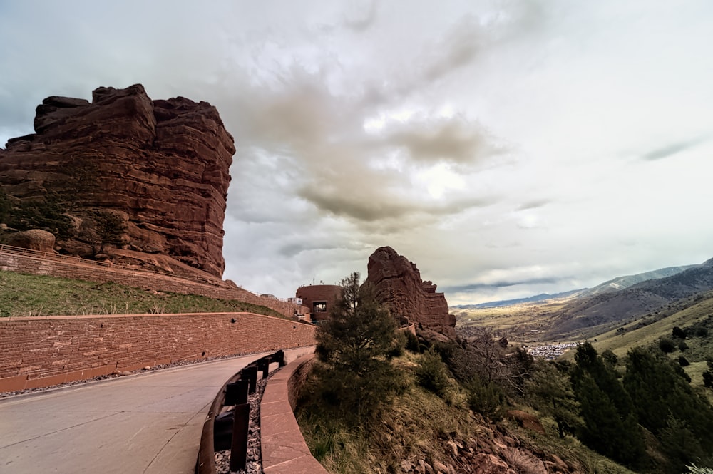 a car driving down a road next to a mountain