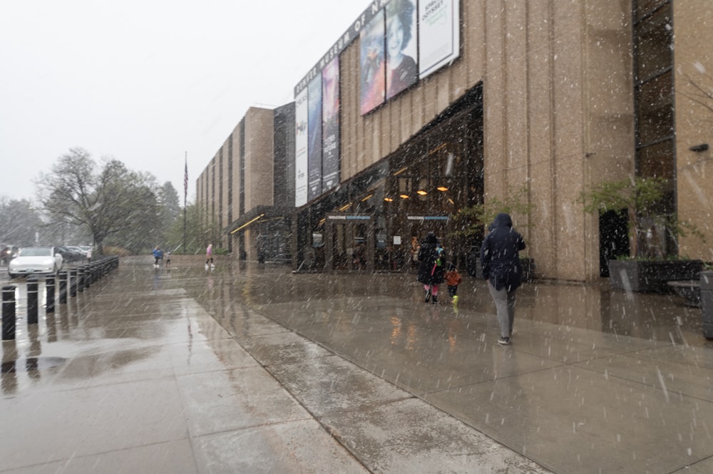 a group of people walking down a street in the rain