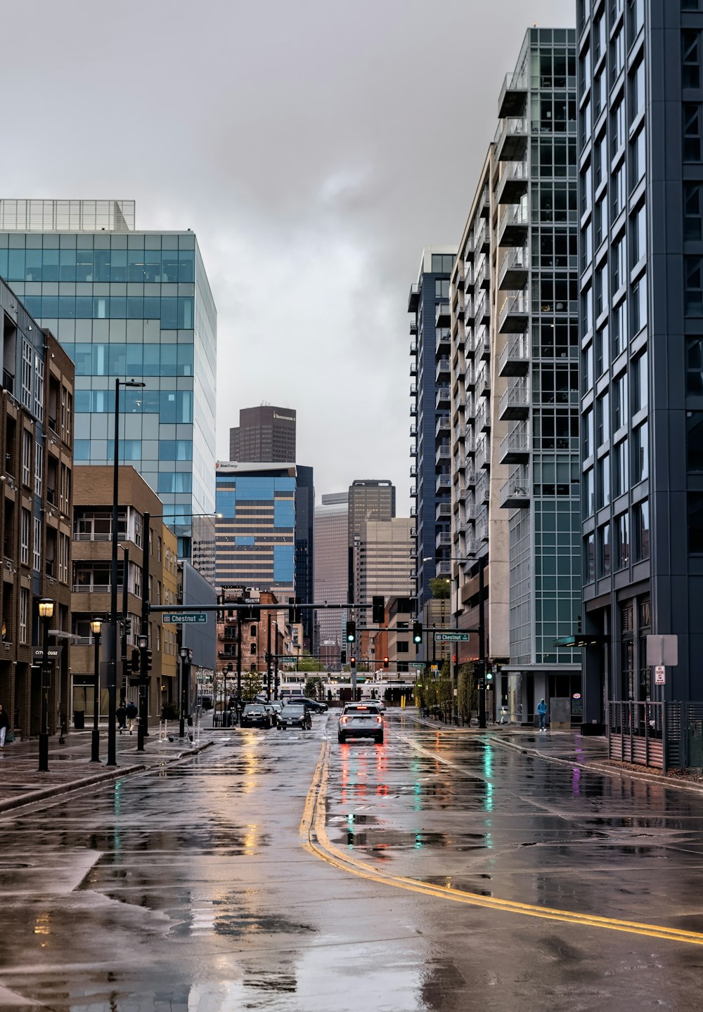 a wet city street with buildings and cars