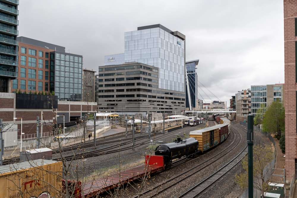 a train traveling down train tracks next to tall buildings