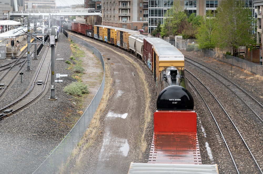 a train traveling down train tracks next to tall buildings