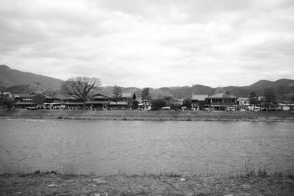a black and white photo of a town by a lake