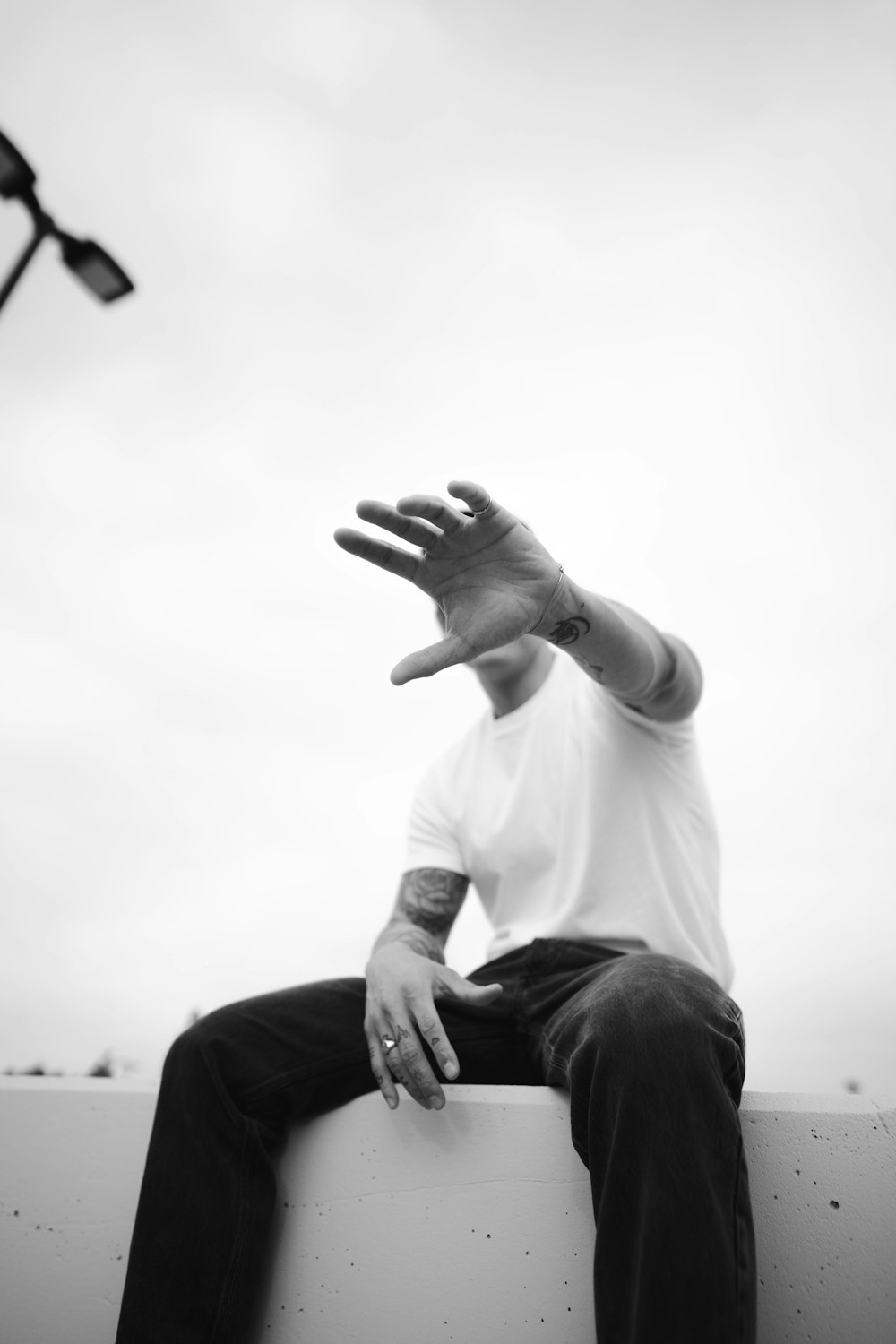 a man sitting on top of a cement wall