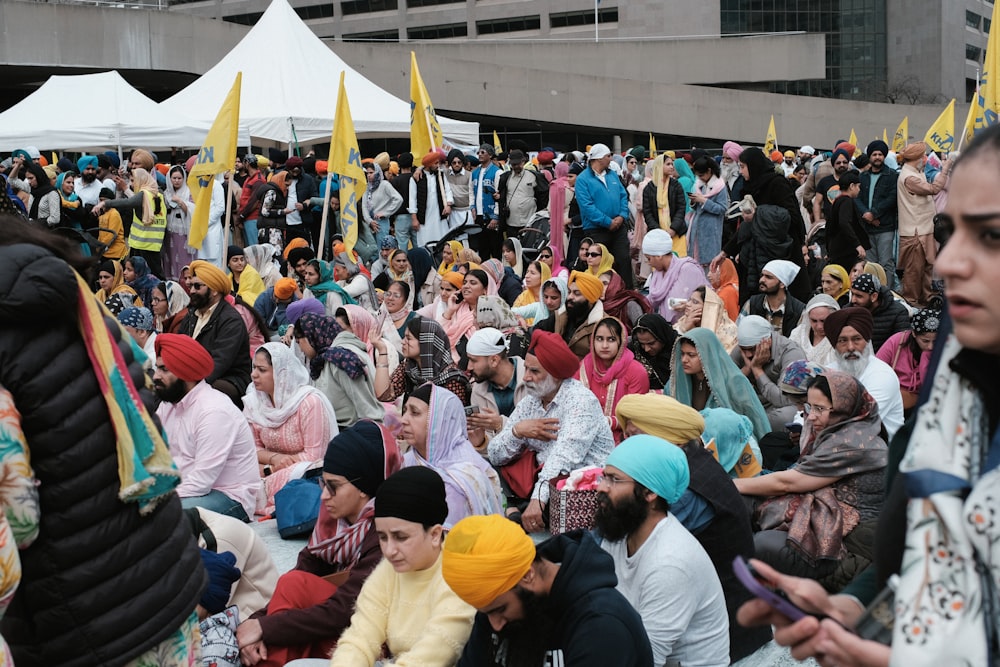 un grand groupe de personnes assises sur le sol