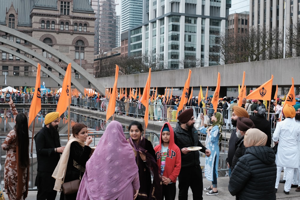 a group of people standing around each other holding orange flags