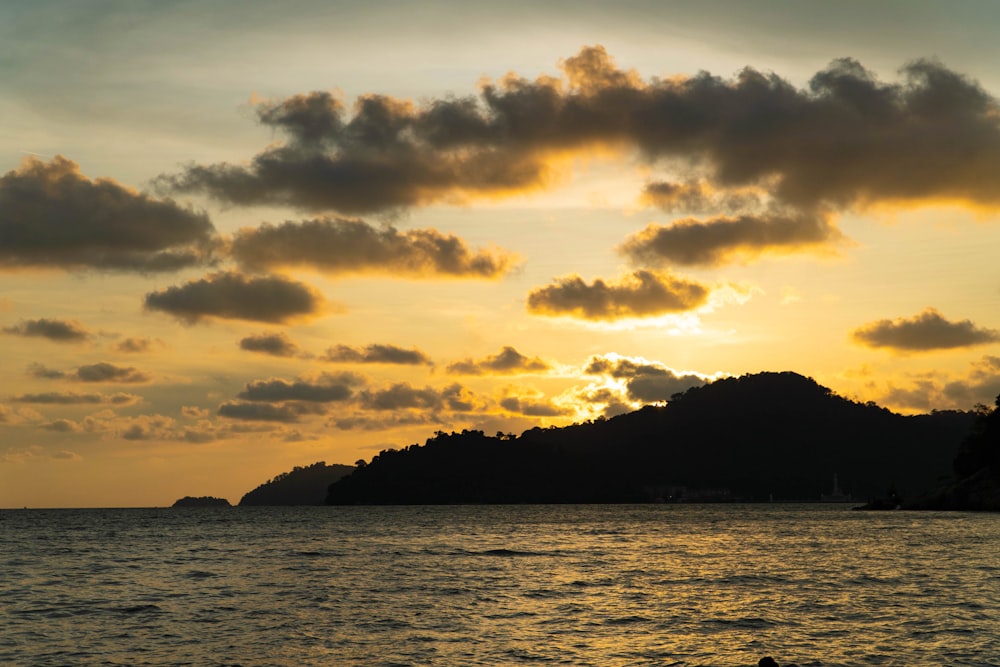 the sun is setting over a small island in the ocean