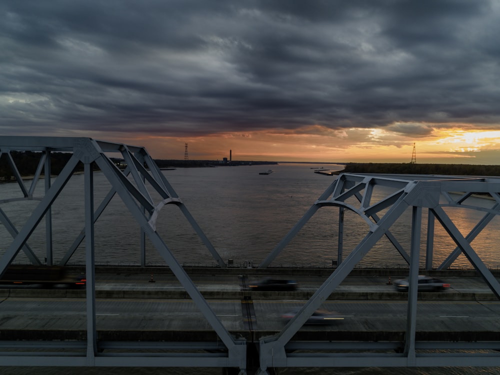 Die Sonne geht über einer Brücke über einem Gewässer unter