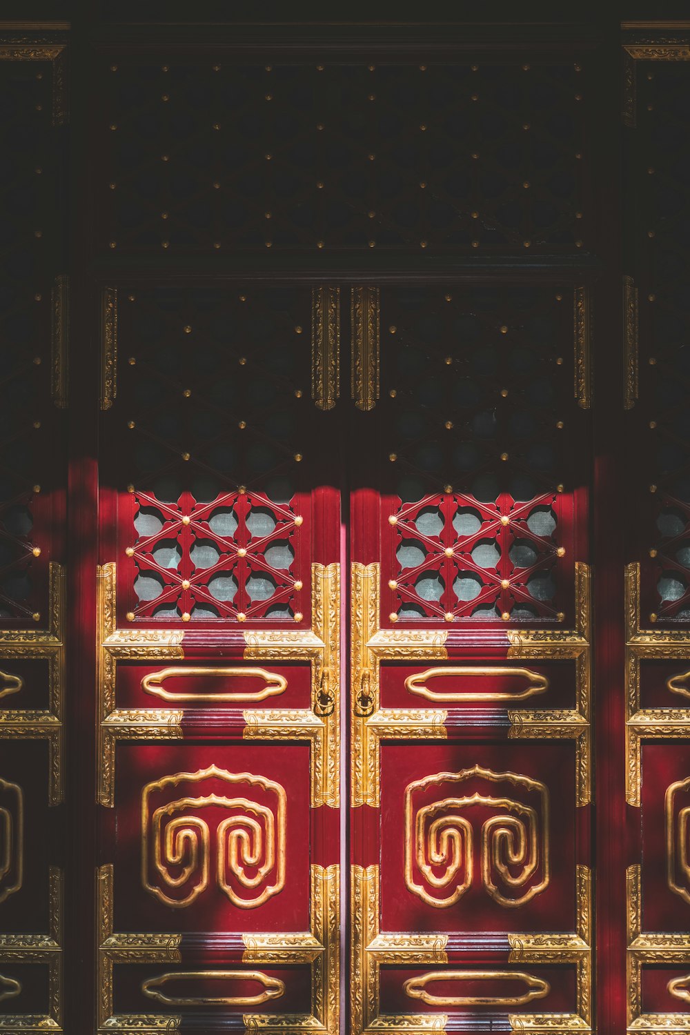 a close up of a red and gold door