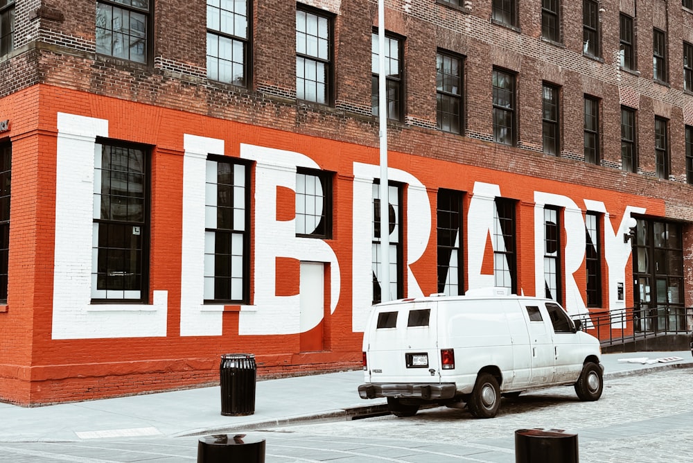 a white truck parked in front of a library