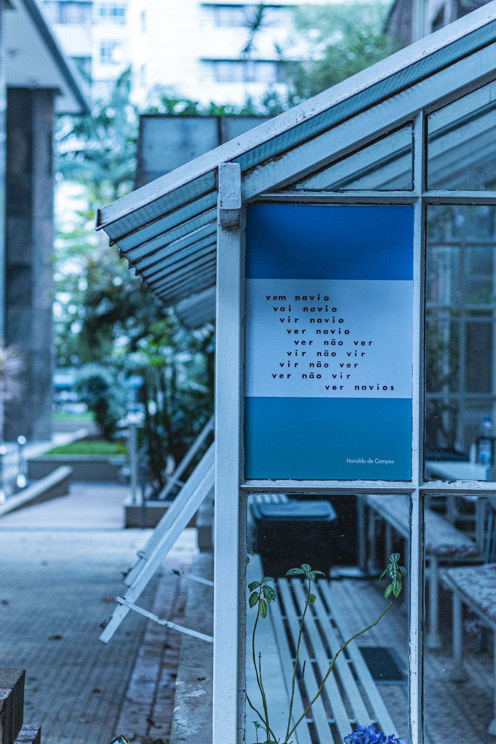 a blue and white sign sitting on the side of a building