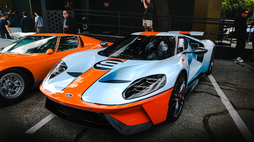 two orange and blue sports cars parked next to each other