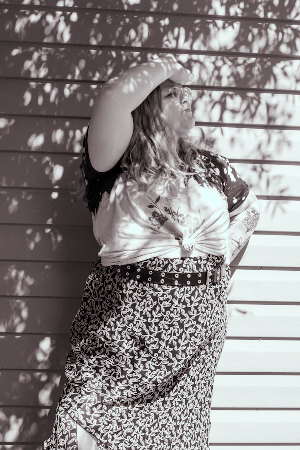 Woman in stylish outfit confidently posing against urban backdrop