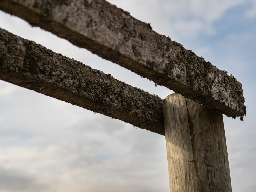 a close up of a wooden fence with a sky in the background