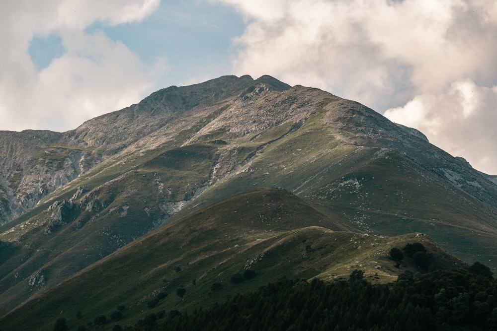 a very tall mountain with some clouds in the sky