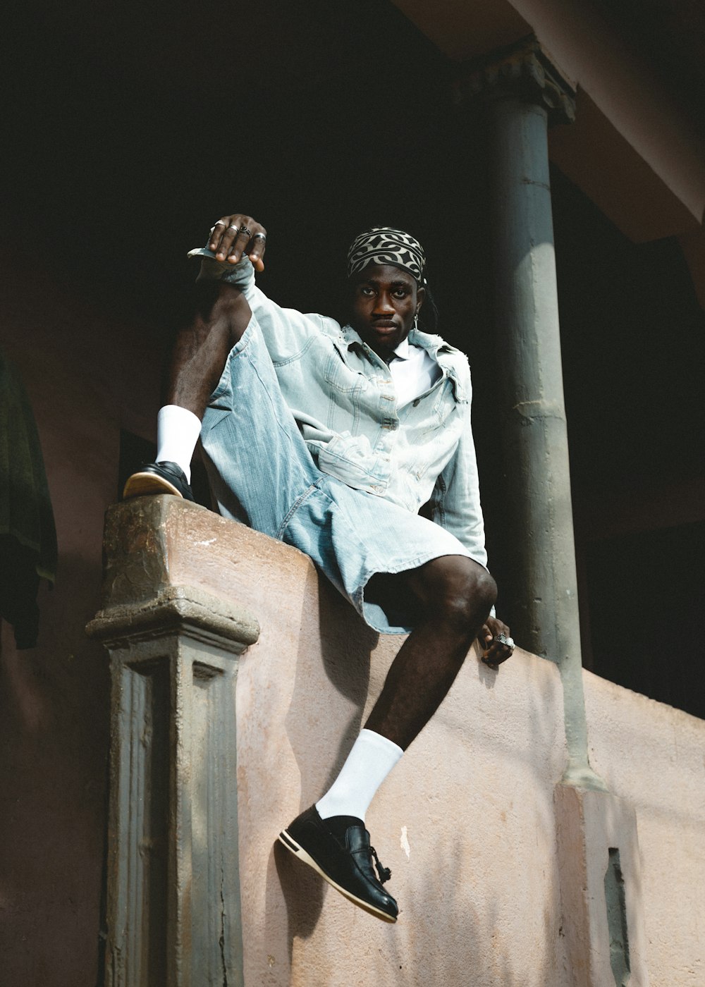 a man sitting on top of a stone wall