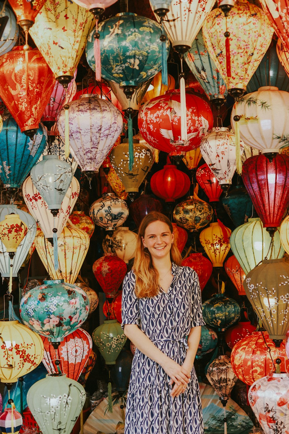 a woman standing in front of a wall of balloons