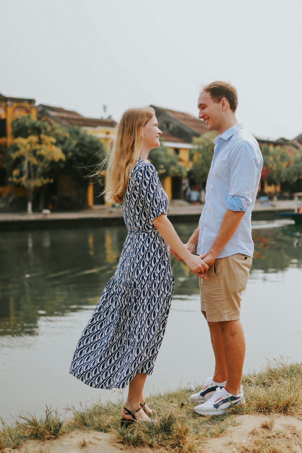 a man and a woman holding hands by the water