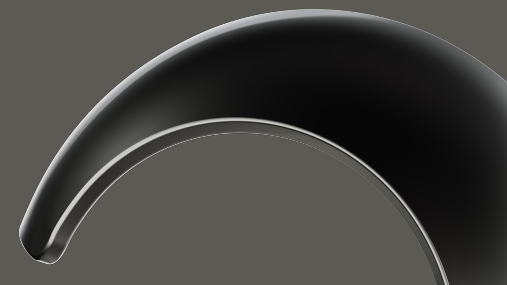 a black curved object on a gray background