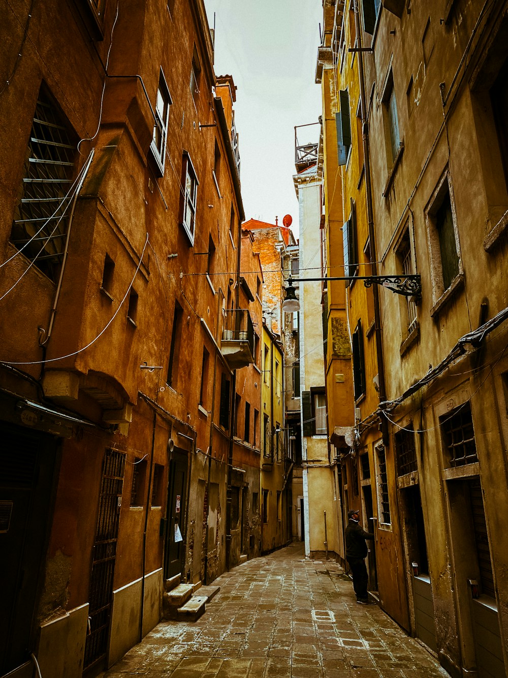 a narrow alley way with a person walking down it