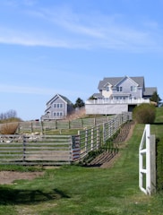 a fenced in field with a house in the background
