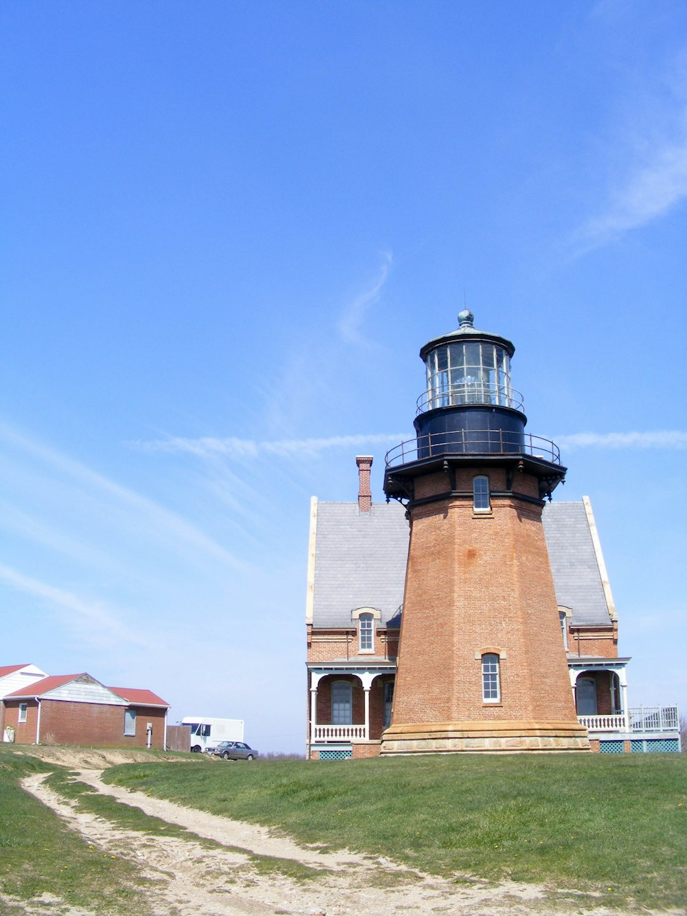 a light house sitting on top of a lush green field