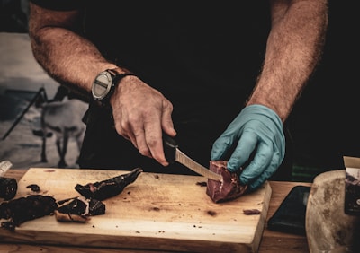 a man cutting up a piece of meat on a cutting board